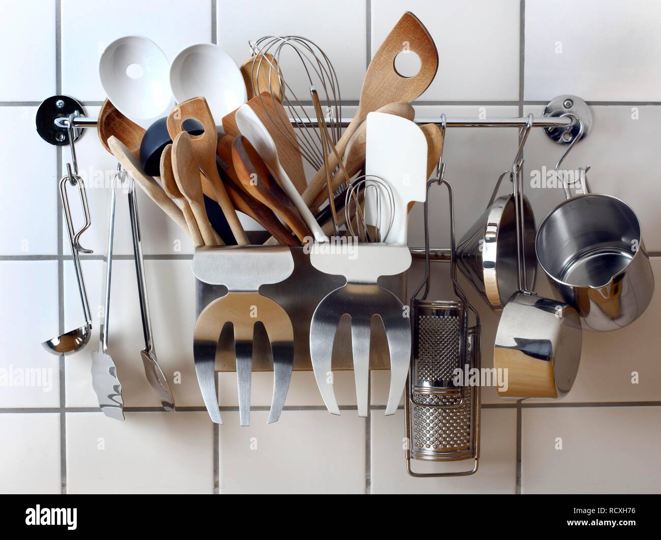 Various kitchen tools and utensils, hanging on a wall in a kitchen ...