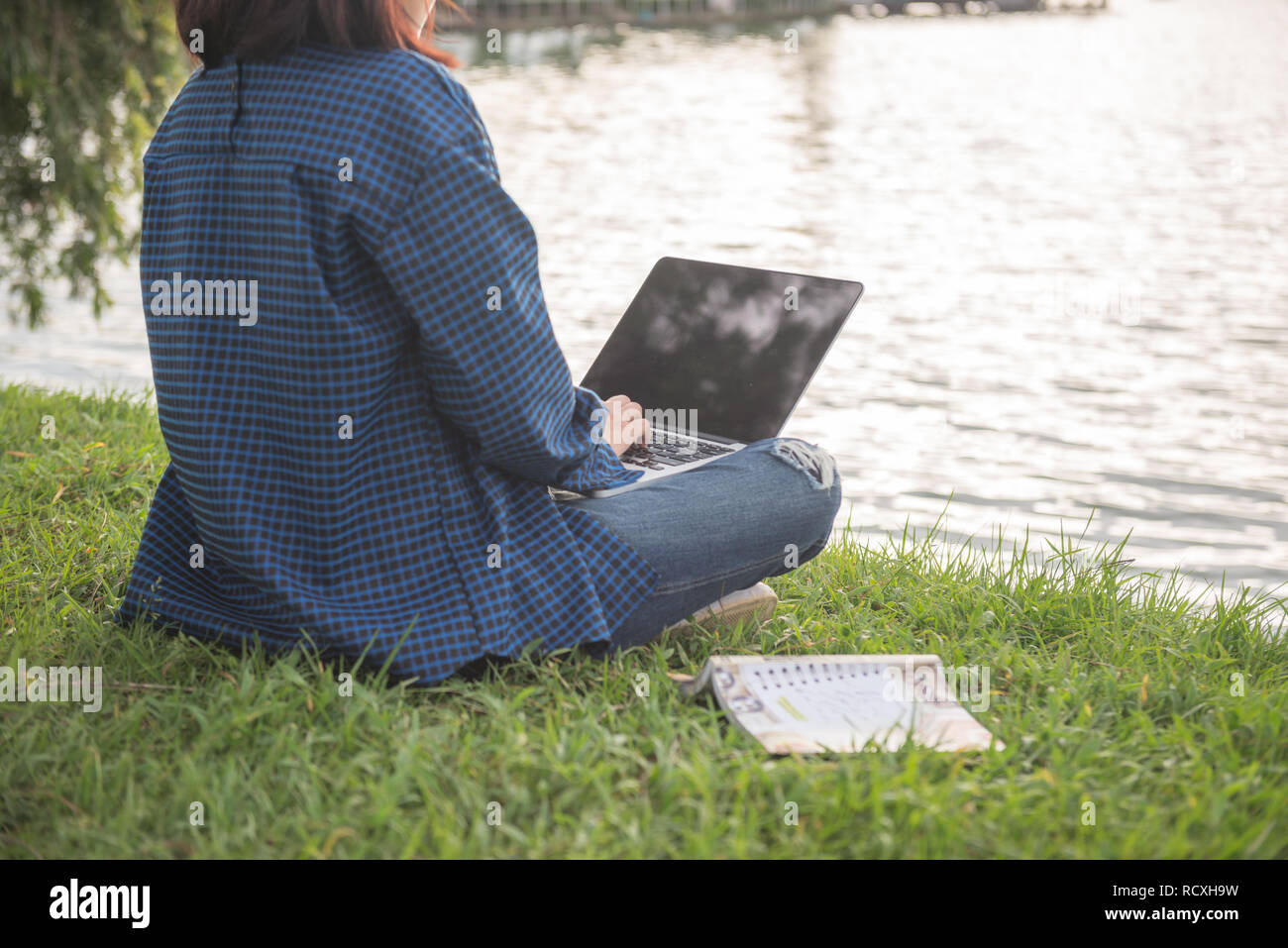 Asian girl using laptop in the green park Stock Photo - Alamy