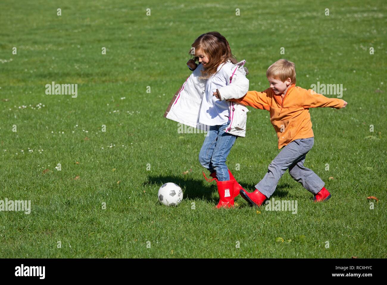 Girl and boy playing soccer Stock Photo