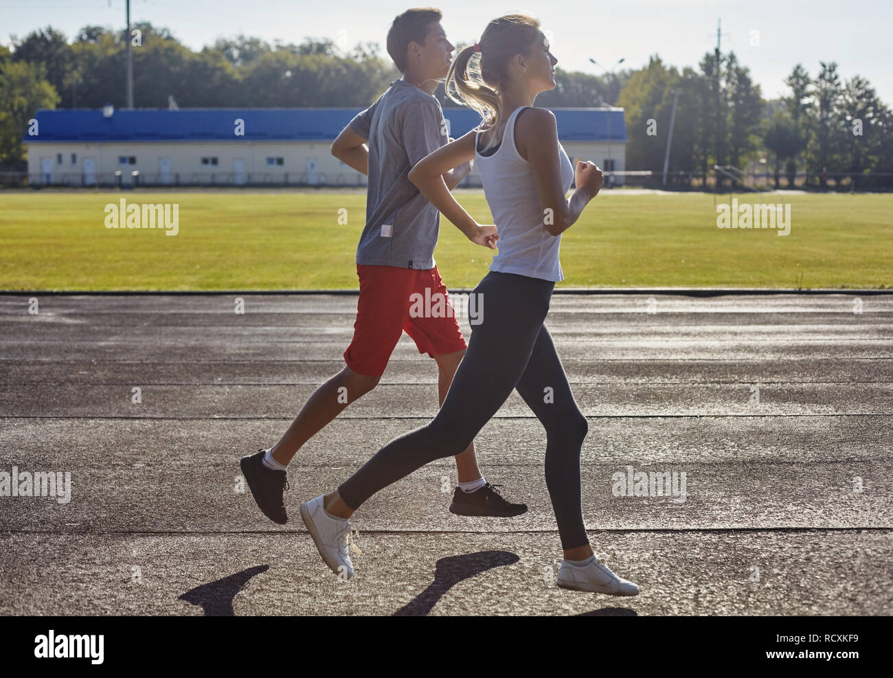 Young people running outdoors. Couple of runners on morning run. Stock Photo