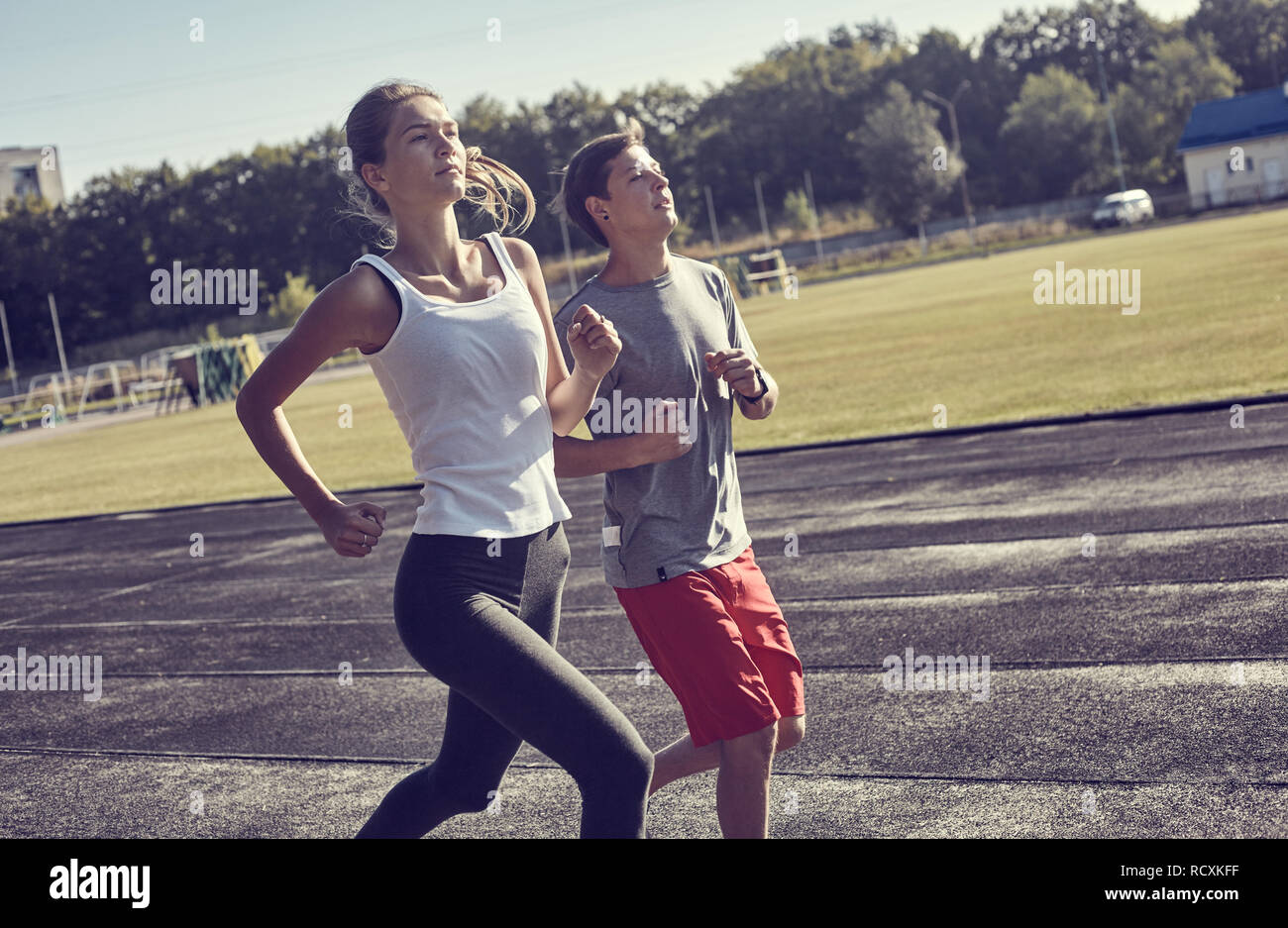 Young people running outdoors. Couple of runners on morning run. Stock Photo