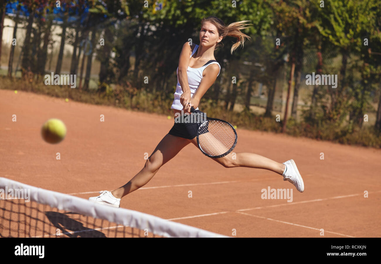 a Girl playing tennis on the court on a beautiful sunny day Stock Photo