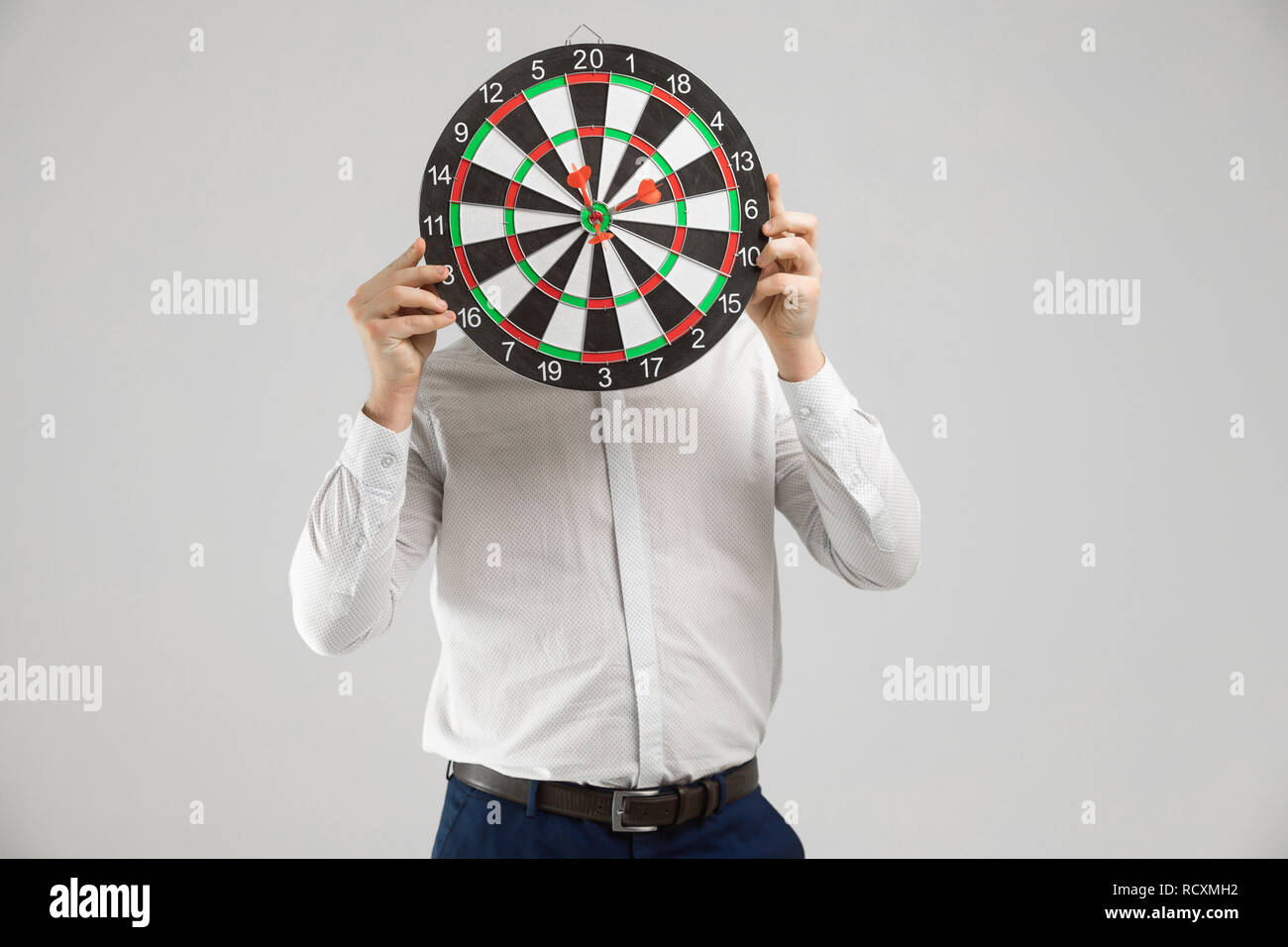 Businessman in a white shirt hid his head behind a target with Darts in  center isolated on a white background Stock Photo - Alamy