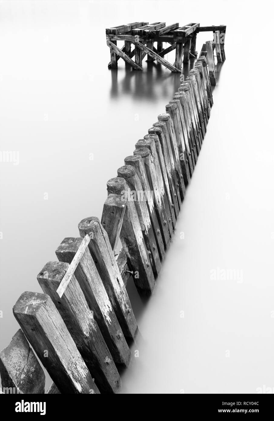 Theres many old remains of the wooden piers in the River Tyne and many of them have some lovely geometric forms. Using a long exposure to soften the w Stock Photo