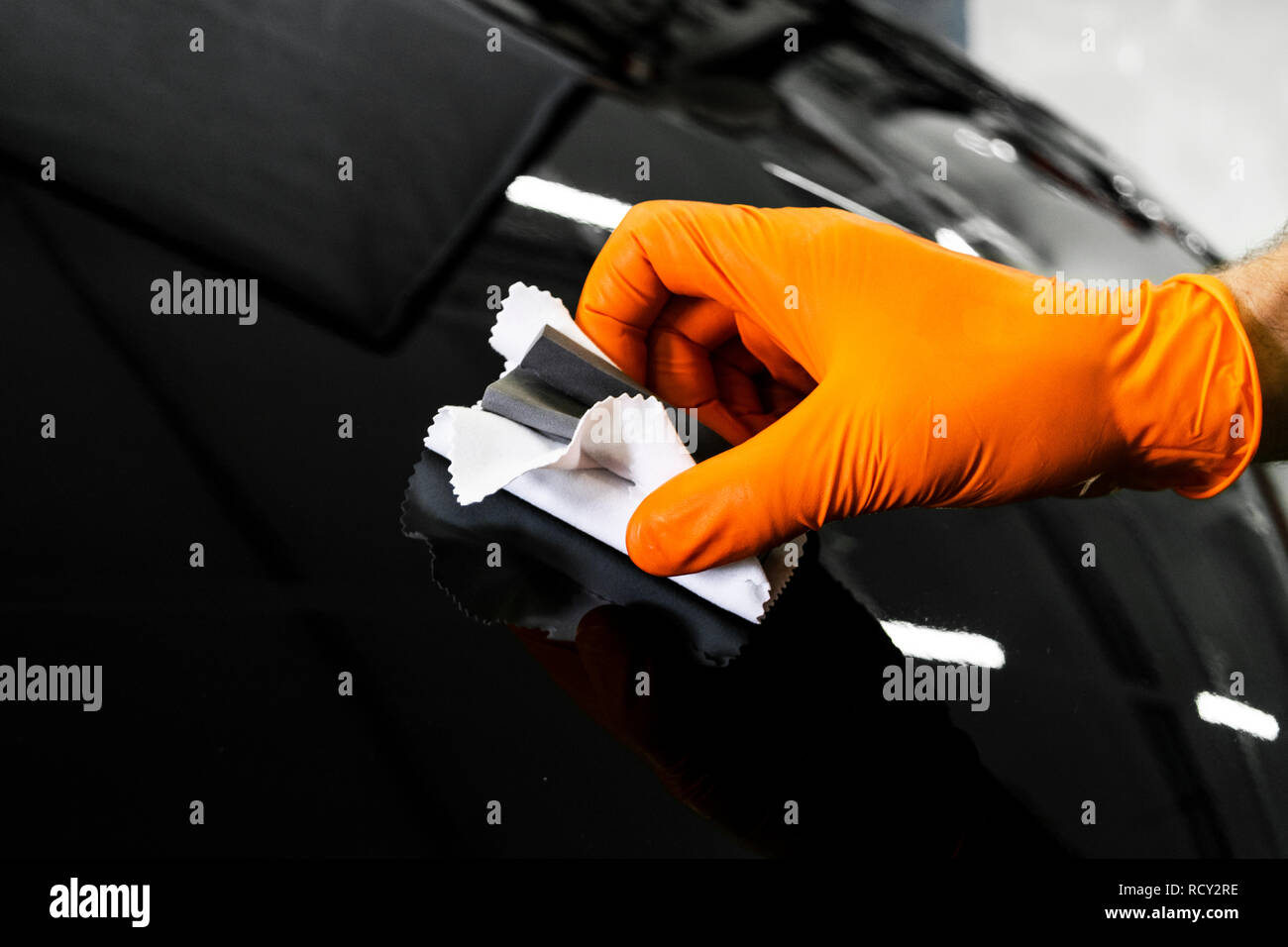 Car polish wax worker hands polishing car. Buffing and polishing vehicle. Car detailing. Man