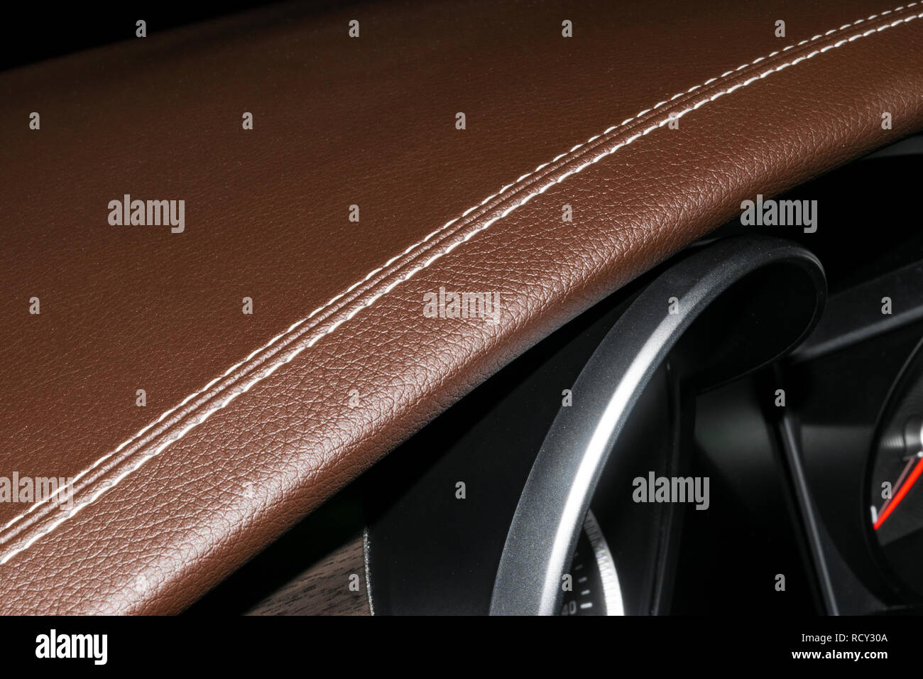 Modern sport car brown leather interior. Part of leather car cockpit details with stitching. Car detailing. Brown perforated leather cockpit. Stock Photo