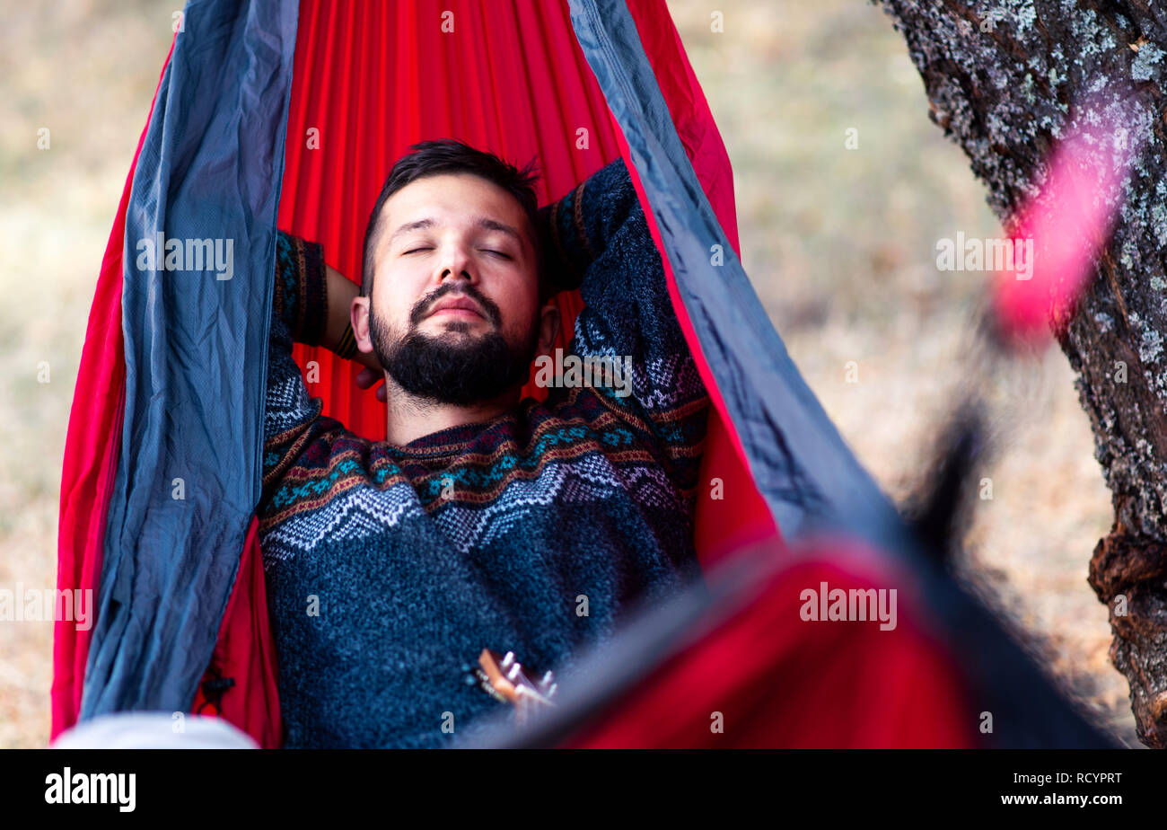 Man relaxing in a hammock on a hiking trip Stock Photo