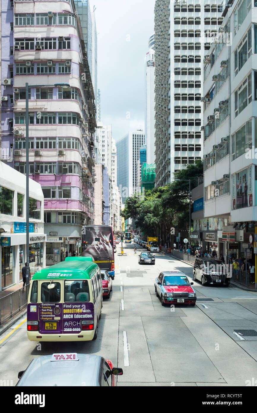 Narrow street in Hong Kong with tall buildings on either side Stock Photo