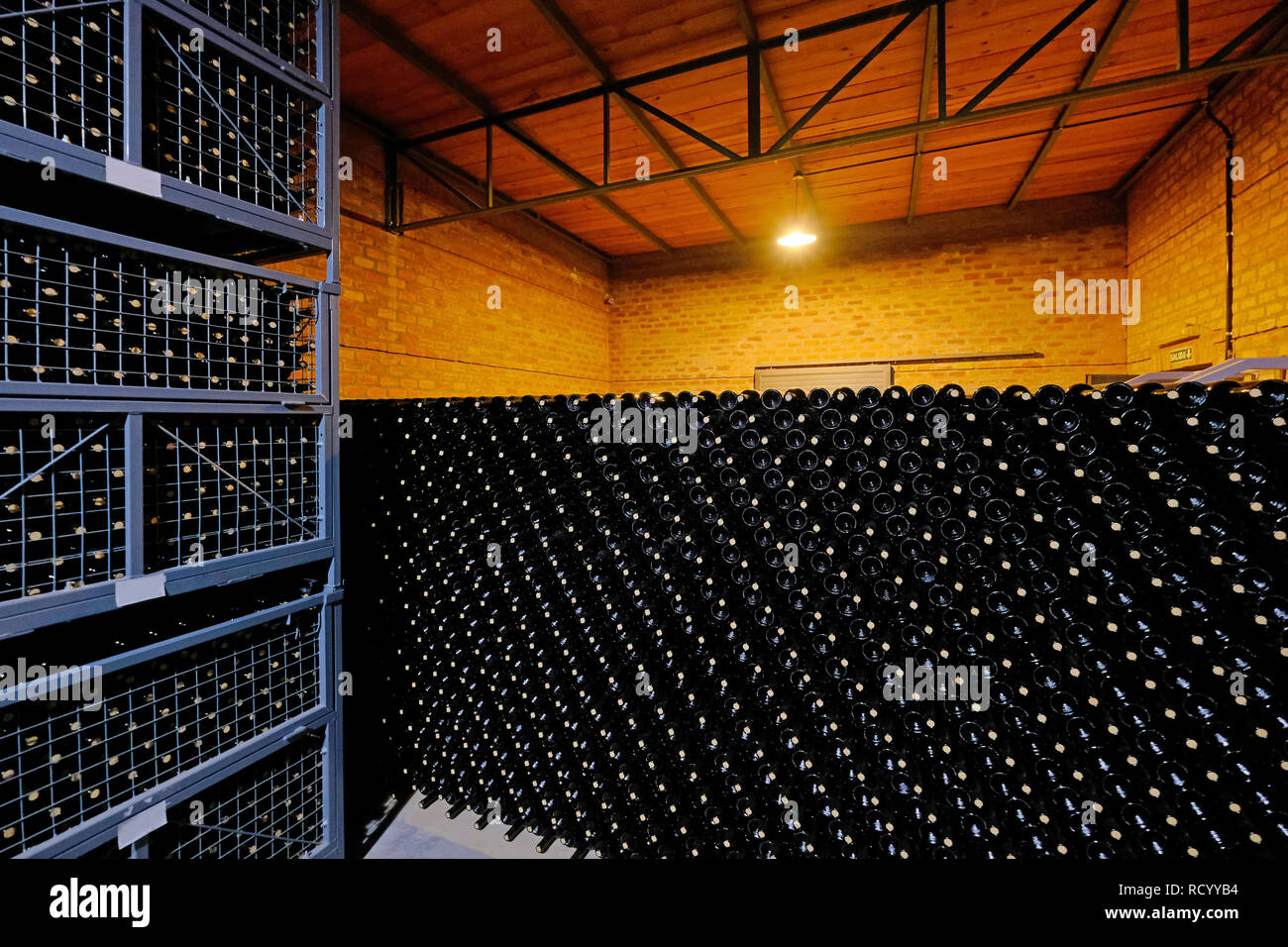 Resting wine bottles stacked in the cellar of a Malbec winery factory