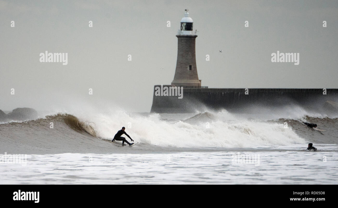Surfers take on the big waves at Tynemouth as the Met Office has issued a yellow warning for snow and ice in Northern Scotland and for ice in the rest of the UK apart from South East England as temperatures drop overnight. Stock Photo