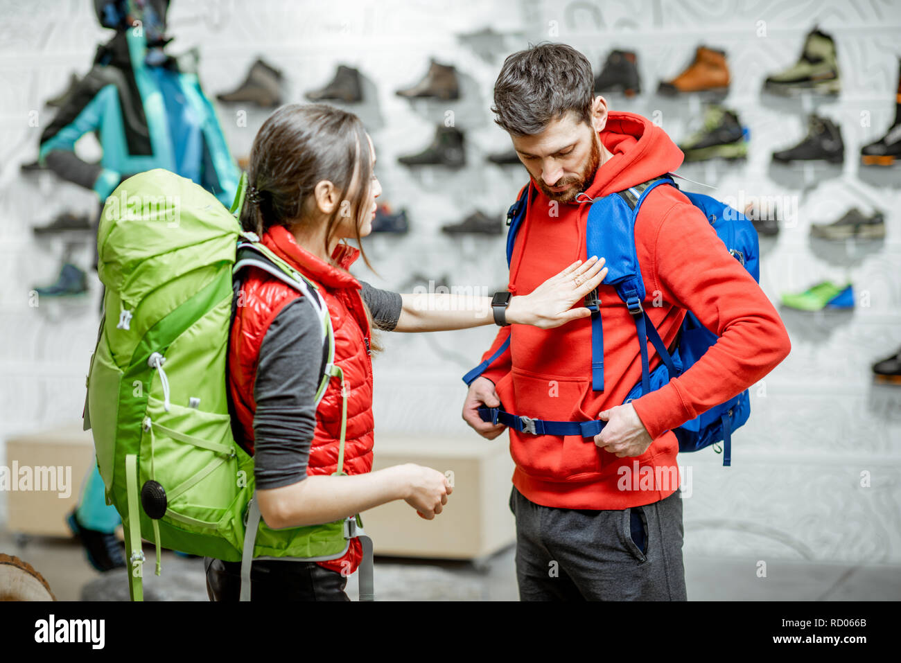 Young couple of travelers trying new backpacks in the shop with sports  clothes and equipment Stock Photo - Alamy