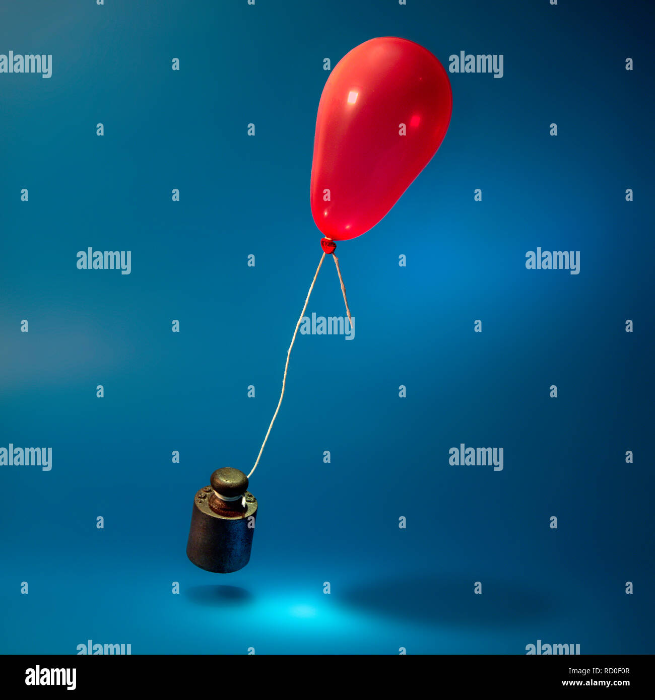 Weight tied to a balloon Stock Photo
