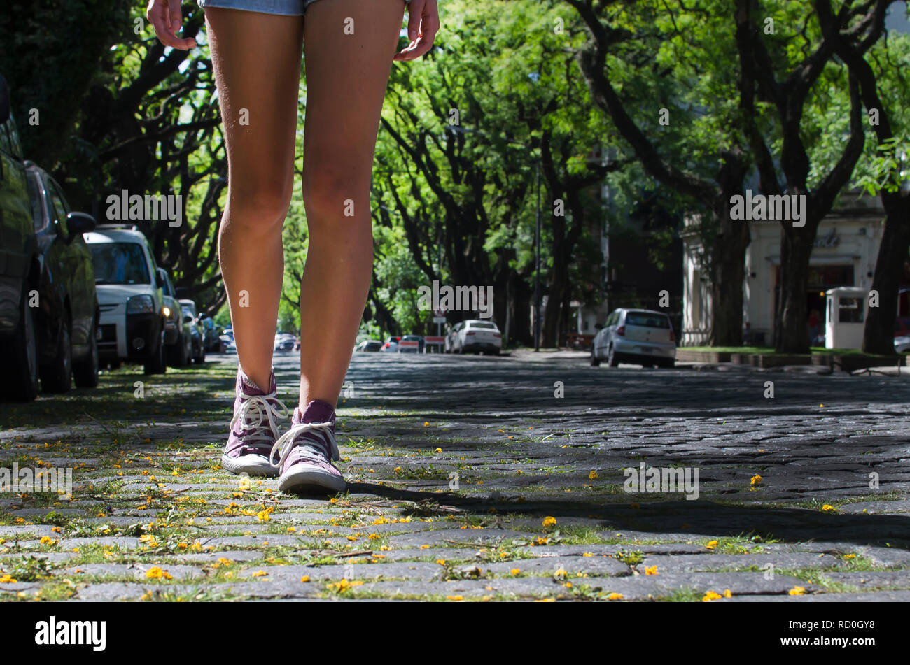 Close-up of a girl's legs walking down city street, Argentina Stock Photo