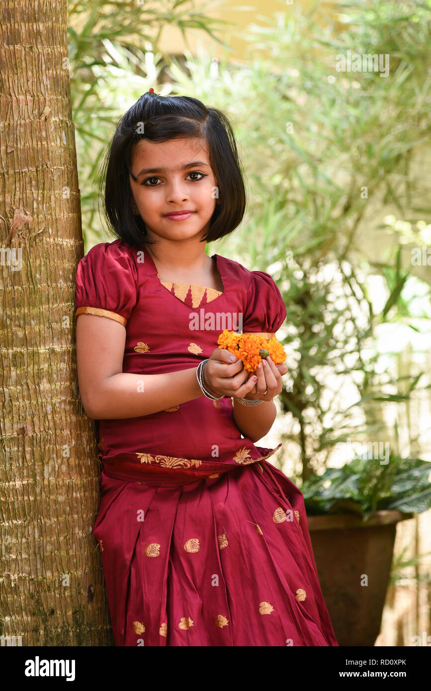 Young Indian girl child wearing traditional dress sari, full skirt for Onam,  Vishu festival Kerala India. Happy beautiful daughter making flower bed  Stock Photo - Alamy