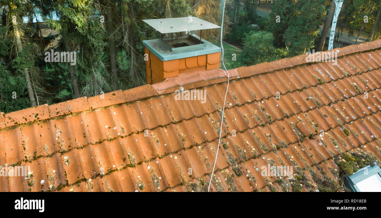 Inspection of the red tiled roof of a single-family house, inspection of the condition of the tiles on one roof side Stock Photo