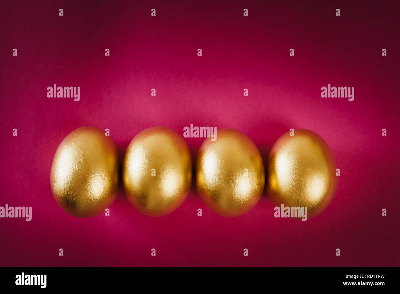 four gold Easter eggs on a purple background Stock Photo