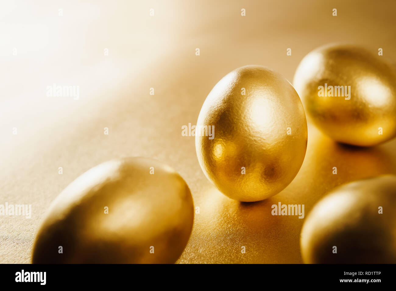 four gold Easter eggs on a shiny background Stock Photo