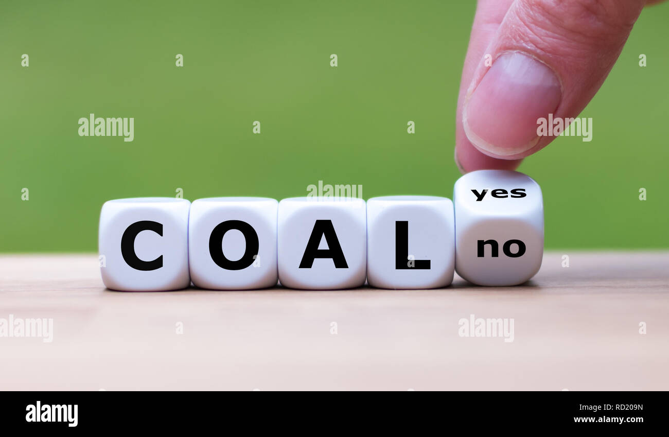 Using coal for energy? Hand flips a dice and changes the word 'yes' to 'no' Stock Photo