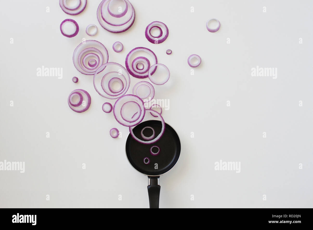 Conceptual red onion ring steam over a frying pan Stock Photo