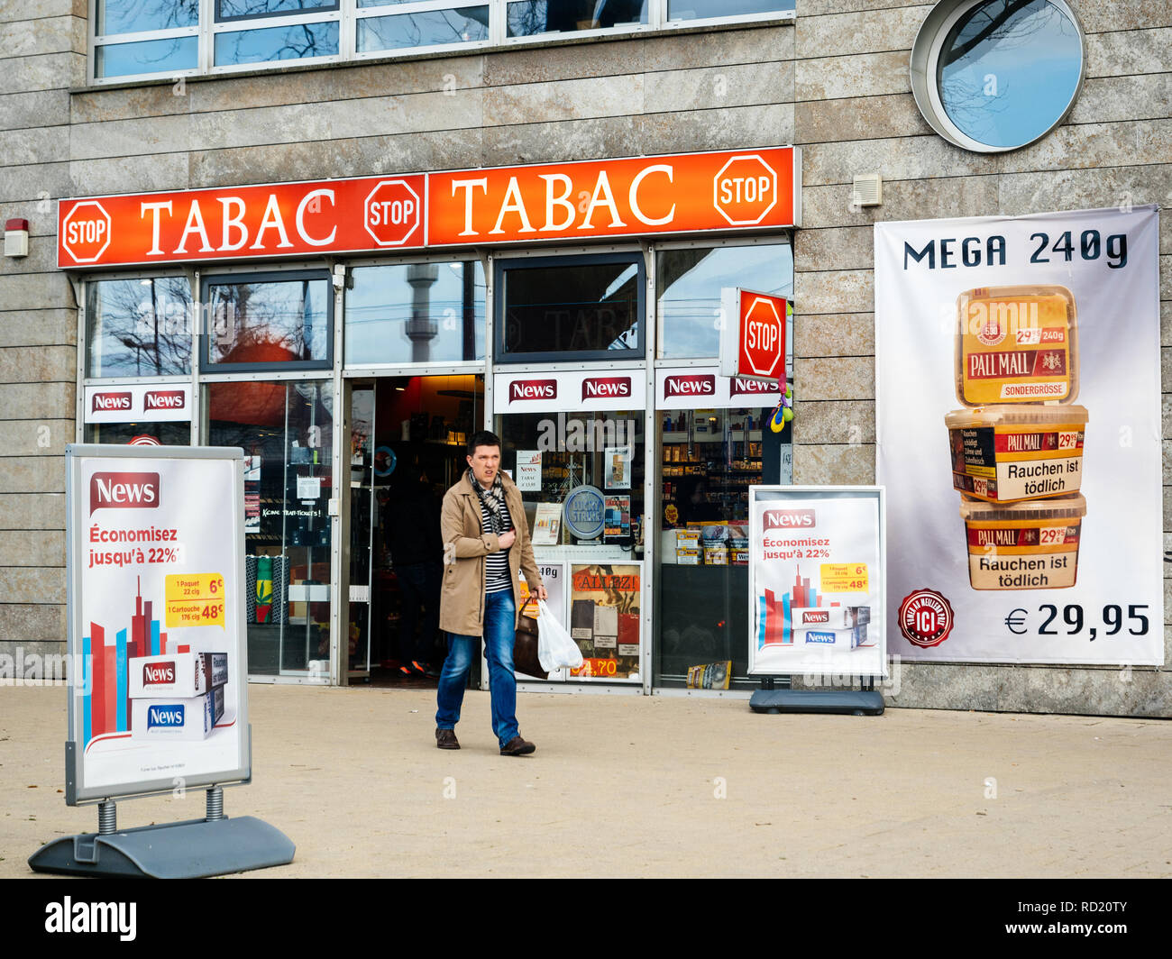 KEHL, GERMANY - MAR 29, 2018: man exit German taback shop offering cheaper than in France cigarettes and tobacco in city of Kehl, Germany 4 km from France Stock Photo