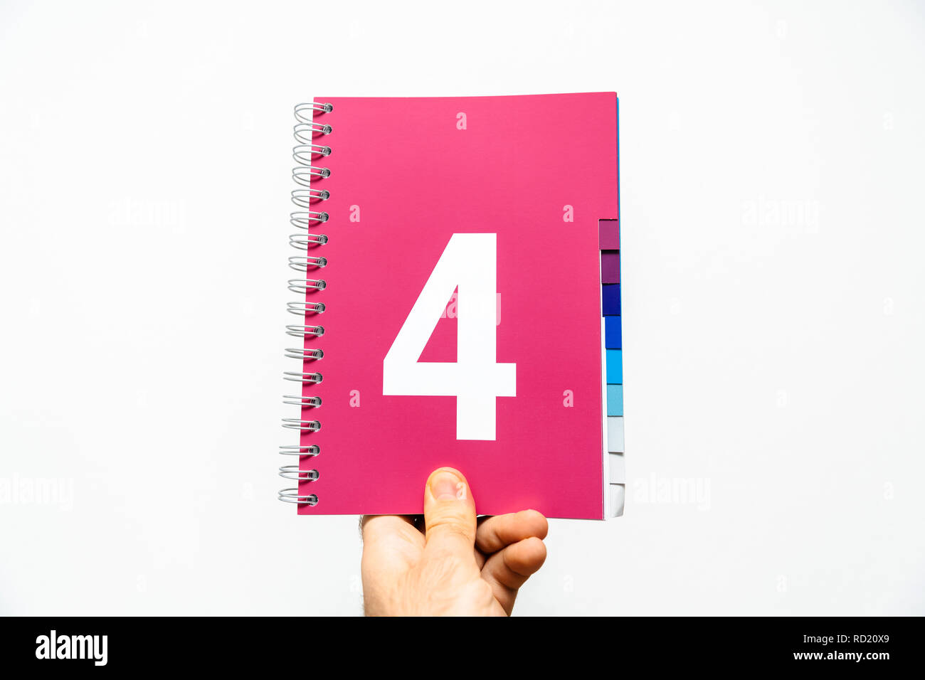 Male hand holding notebook with big number 4 printed onmagenta color ...