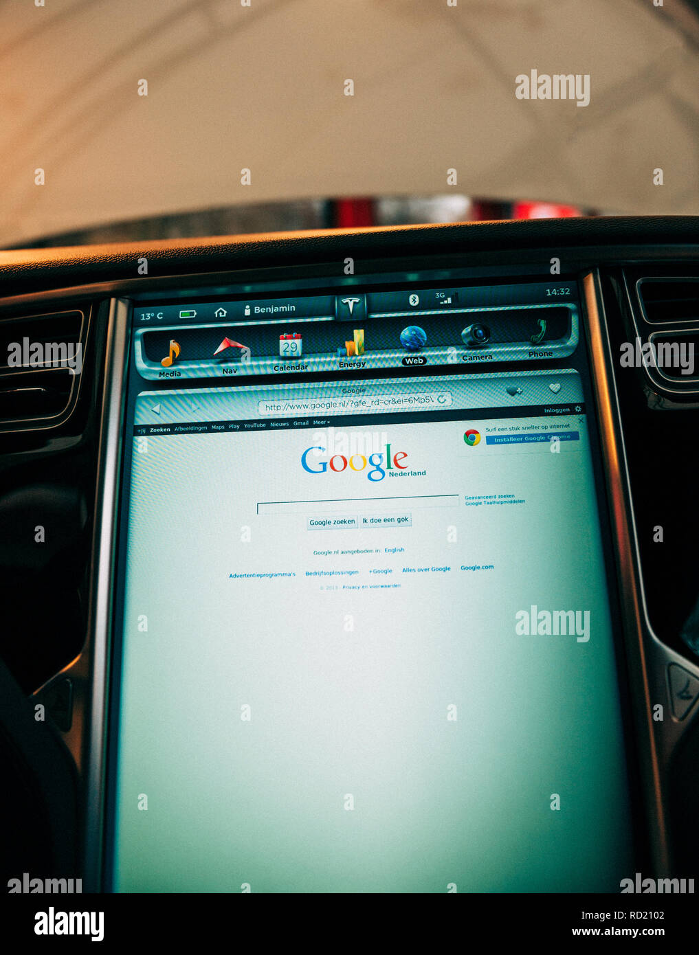 PARIS, FRANCE - NOV 29, 2014: New Tesla Model S dashboard computer display screen with Google browser activated homepage and multiple icons of the car  Stock Photo