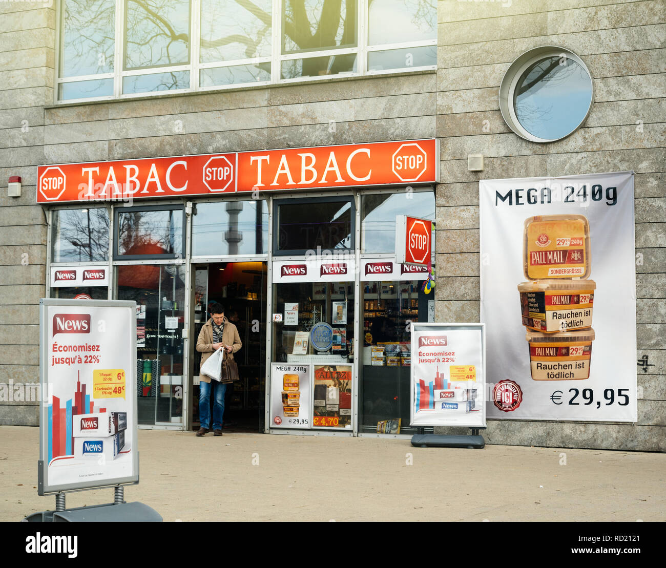 KEHL, GERMANY - MAR 29, 2018: Border shopping - man exit German taback shop offering cheaper than in France cigarettes and tobacco in city of Kehl, Germany 4 km from France Stock Photo