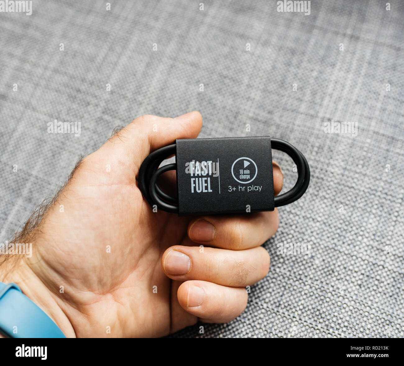 PARIS, FRANCE - MAR 31, 2018: Man unboxing new Apple Beats By Dr Dre Beats Studio 3 Wireless headphones with Pure Adaptive Noise Canceling Pure ANC - fast fuel sign on the connection charging cable Stock Photo