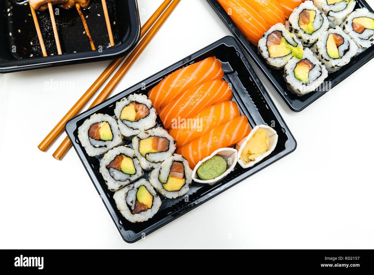 Delicious sushi delivery box with sushi california, maki, sashimi, yakitori  and wooden sticks with wasabi and soy sauce - view from above on the table  Stock Photo - Alamy