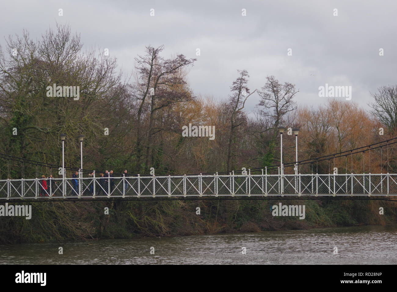 Trews Weir Suspension Bridge over the River Exe on a Grey Winters Day. Exeter, Devon, UK. Stock Photo