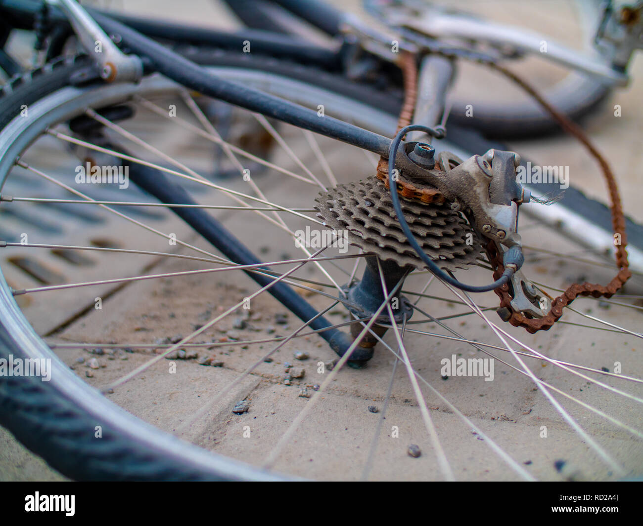 Close up of an old broken and bent bicycle with a rusted chain Stock Photo