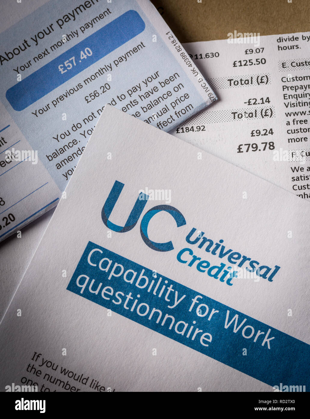UK Universal Credit form with of a pile of unpaid utility bills Stock Photo