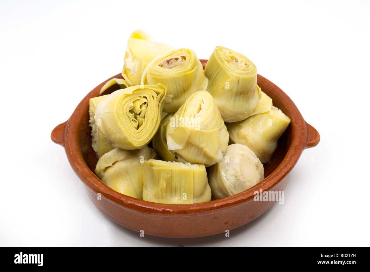 Canned globe artichoke hearts in brine served in a bowl. Imported from Spain and bought from a supermarket in the UK. On a white background. Dorset En Stock Photo