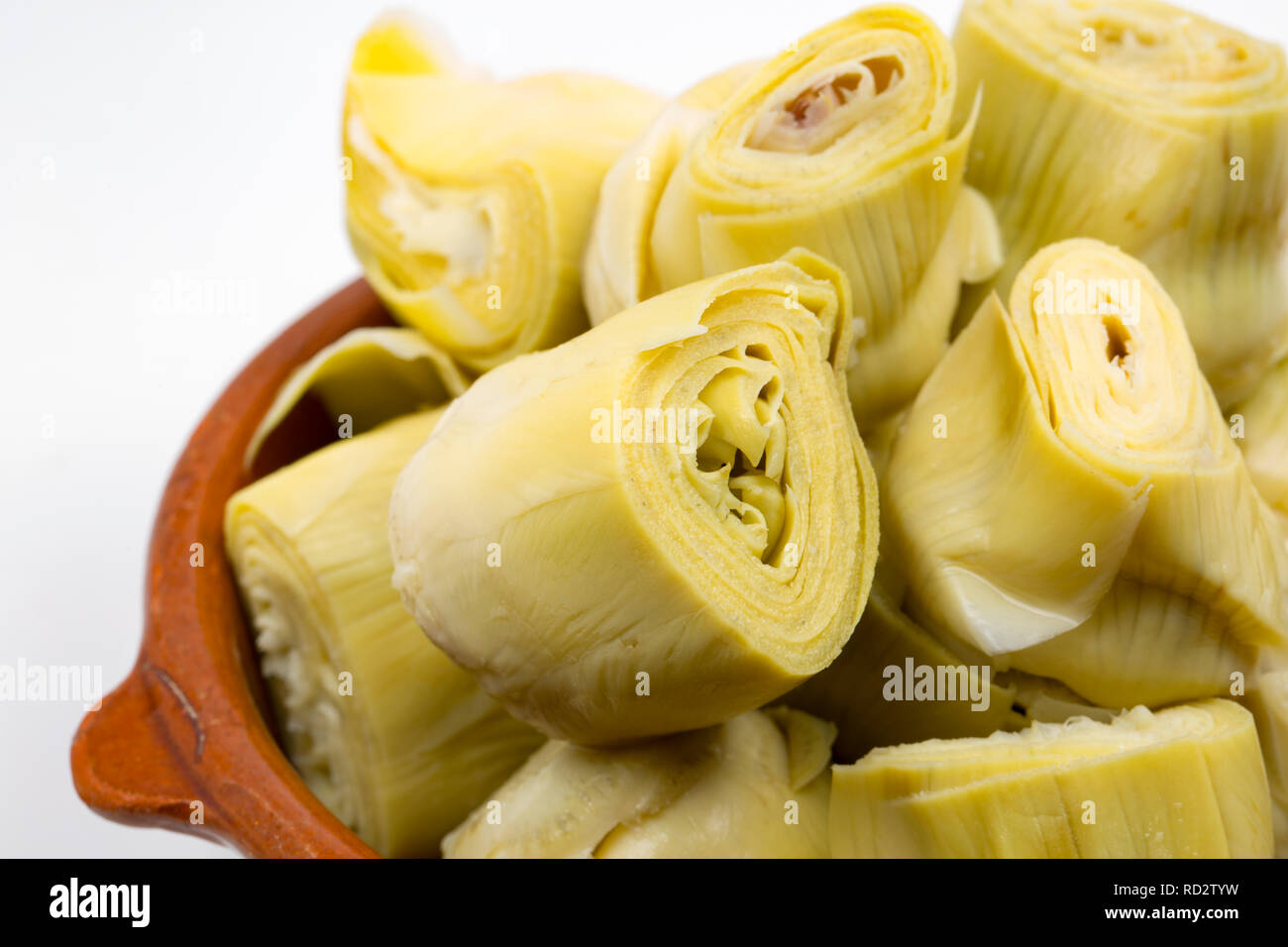 Canned globe artichoke hearts in brine served in a bowl. Imported from Spain and bought from a supermarket in the UK. On a white background. Dorset En Stock Photo