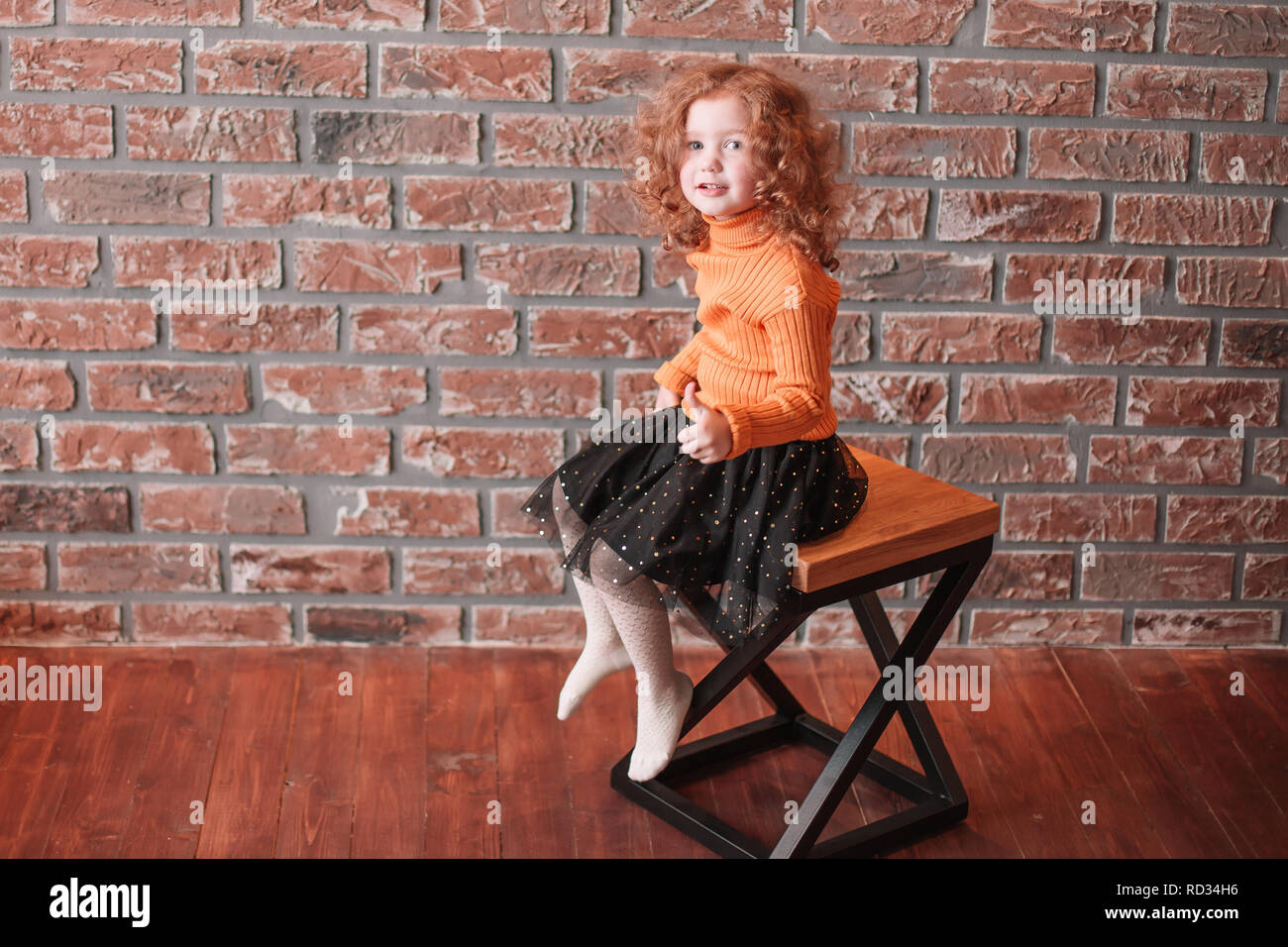 cute little girl sitting on a chair in a new living room Stock Photo ...