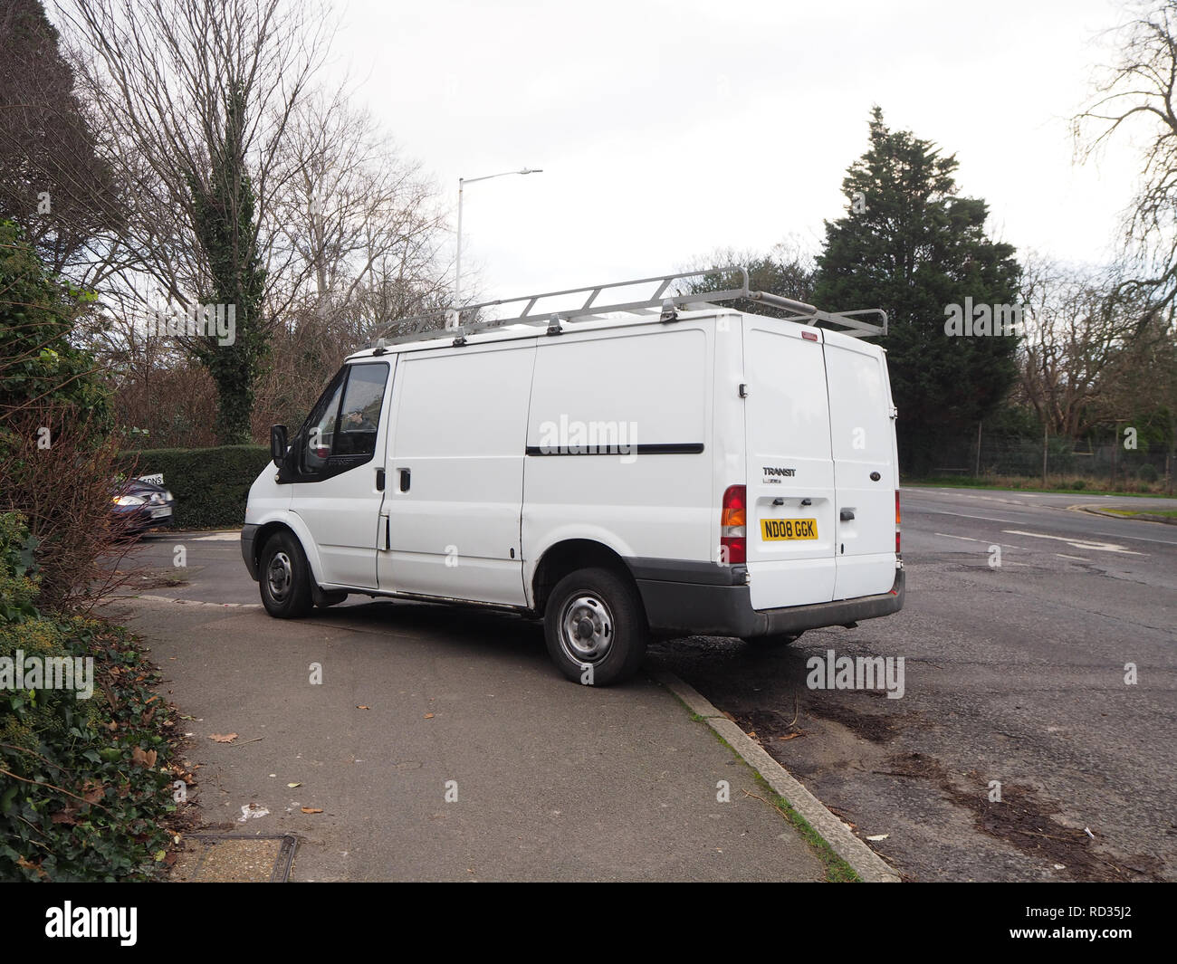 White van parked illegally on a pavement Stock Photo
