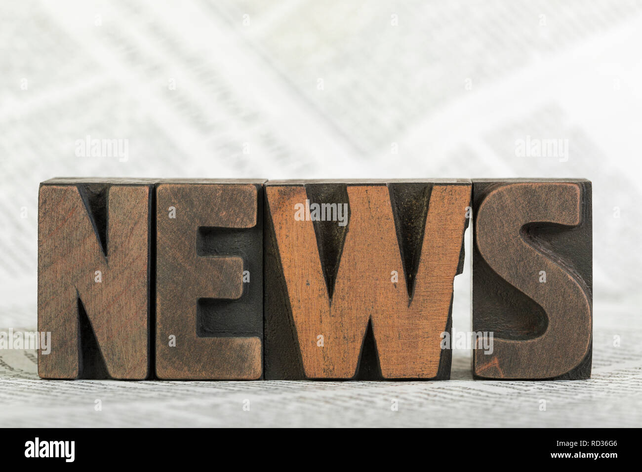 News, word written with vintage wooden letterpress printing blocks on newspaper, shallow depth of field Stock Photo