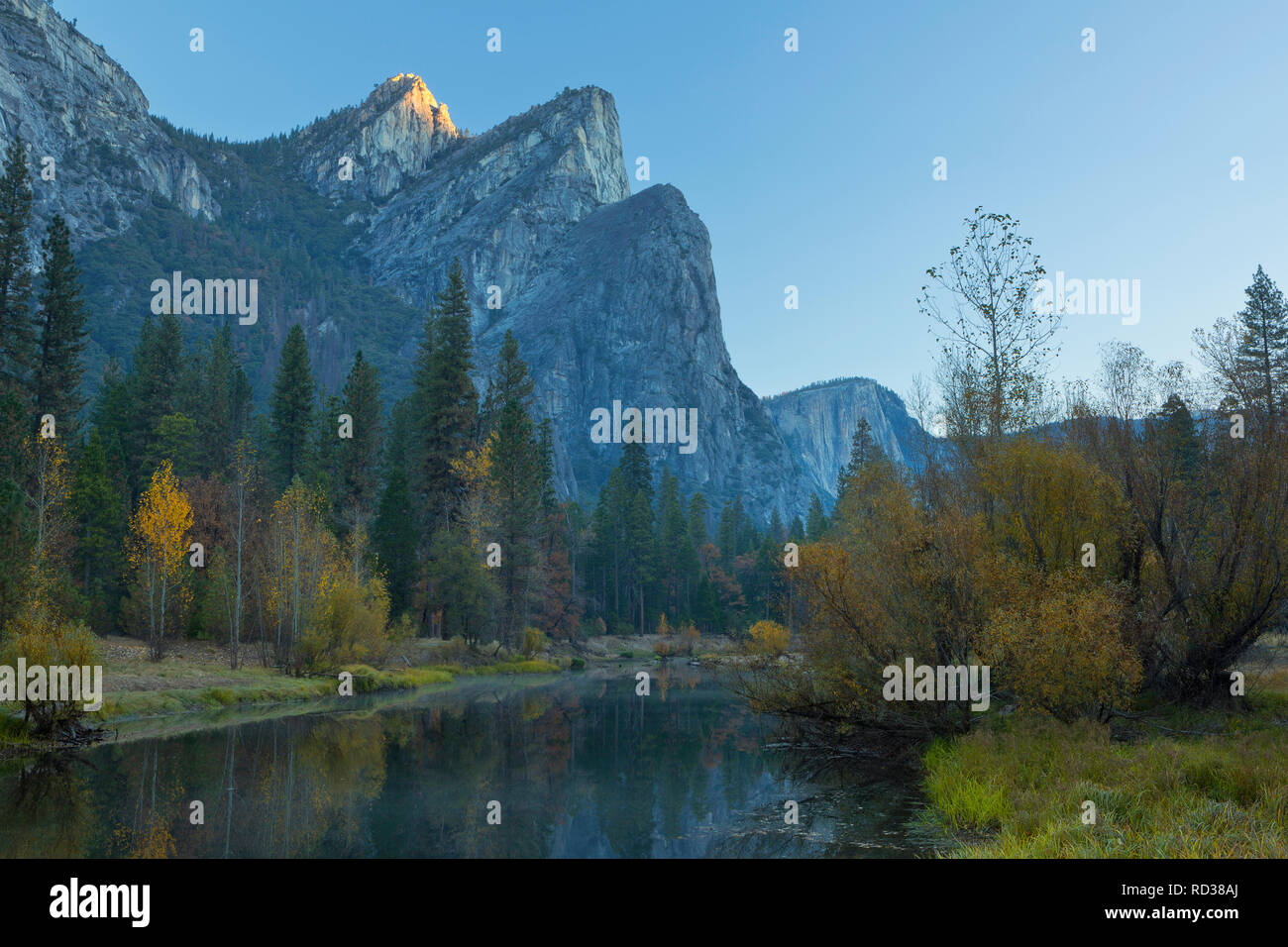 The Three Brothers reflect at morning in the Merced River in Yosemite National Park. California, USA. Fall Stock Photo