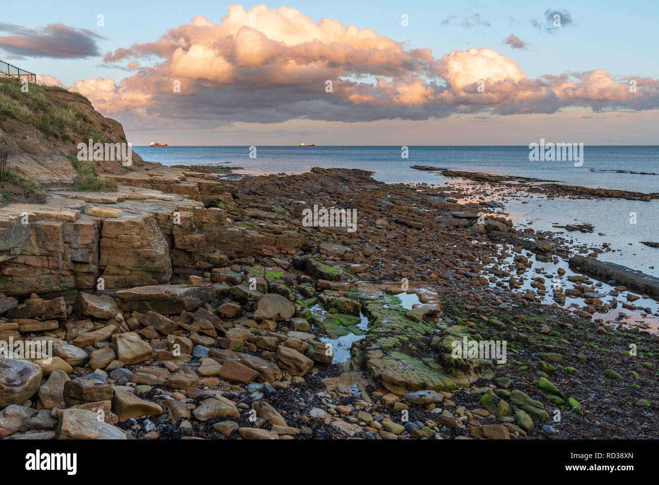 Evening Clouds and cliffs on the North Sea Coast in Cullercoats Bay, Tyne And Wear, England, UK Stock Photo