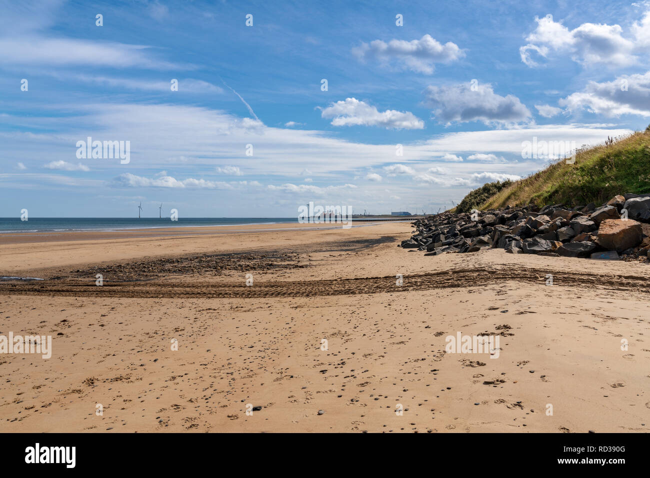 North Sea coast in Cambois, Northumberland, England, UK - the beach with wind turbines in the background Stock Photo