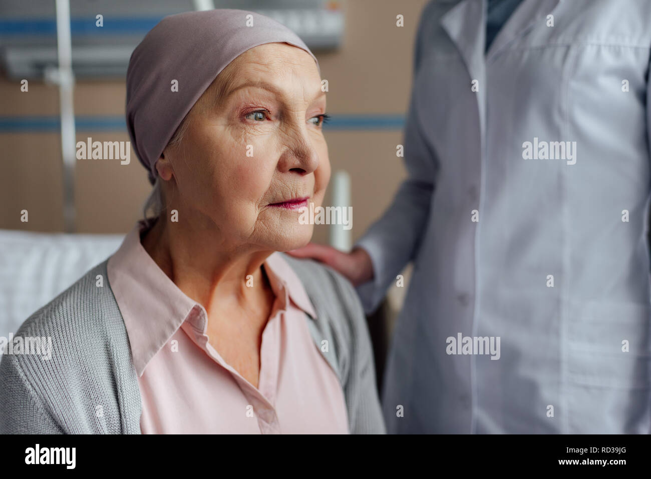 doctor consoling upset senior woman with cancer in hospital Stock Photo