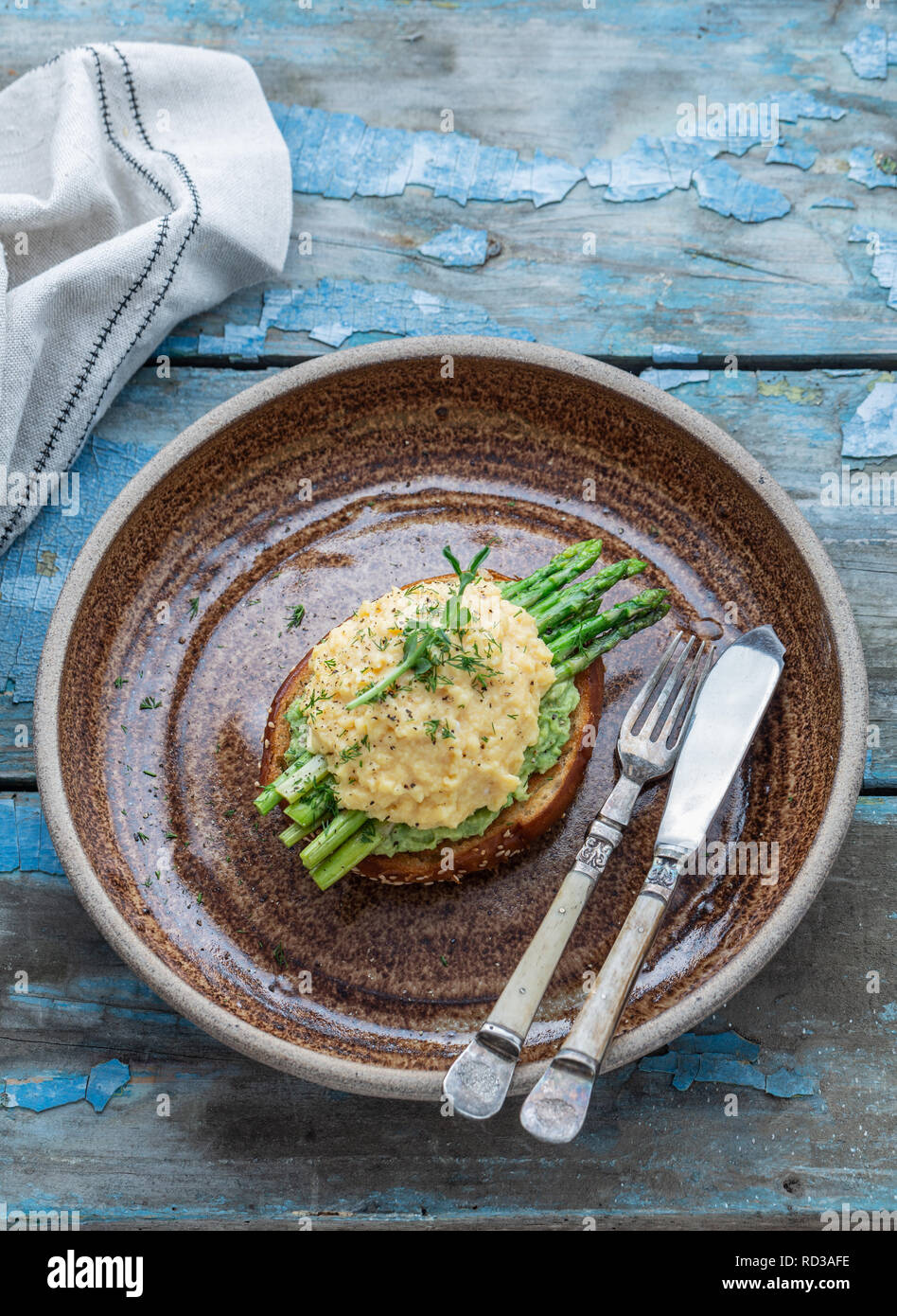 Toasted bread with scrabled eggs and avocado, copy space Stock Photo