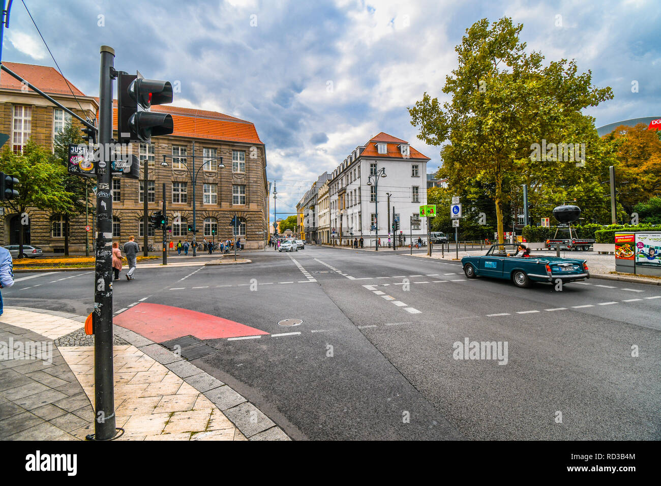 A man drives a convertible vintage car drives through the Mitte district towards Museum Island in the urban center of Berlin, Germany. Stock Photo