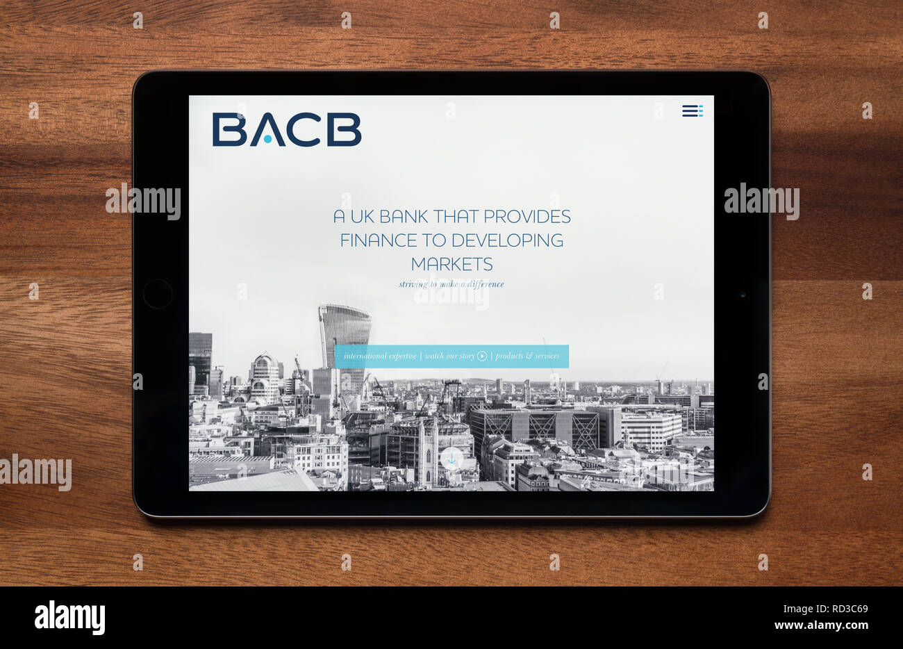 The website of British Arab Commercial Bank (BACB) is seen on an iPad tablet, which is resting on a wooden table (Editorial use only). Stock Photo