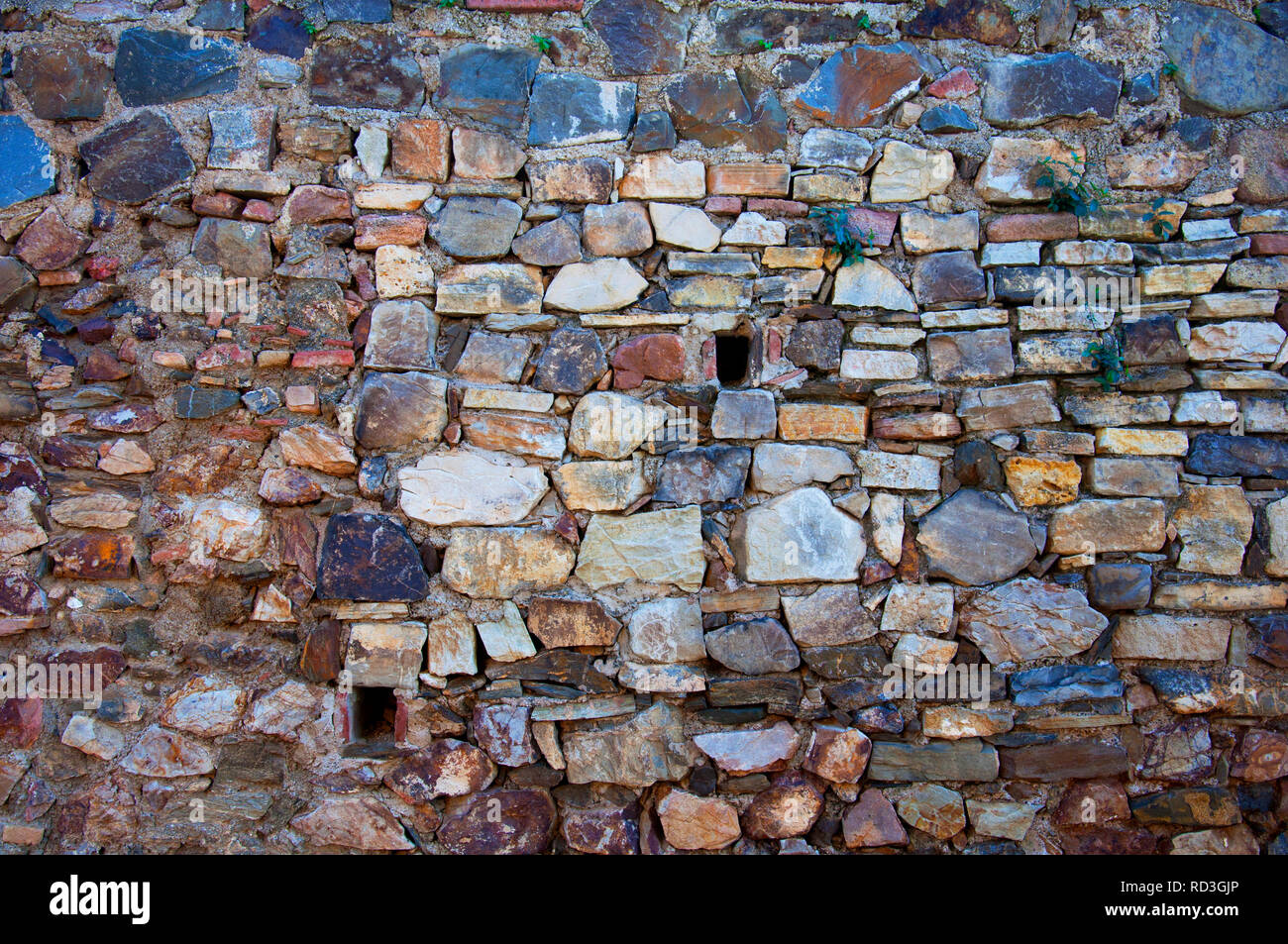 Old stone wall with two small windows, Malaga, Spain Stock Photo