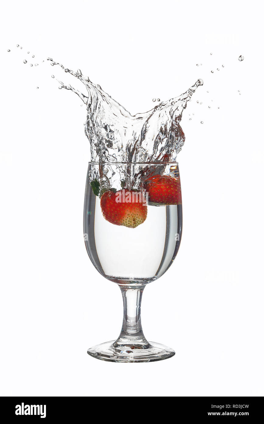 Strawberries splashing in a glass of water Stock Photo