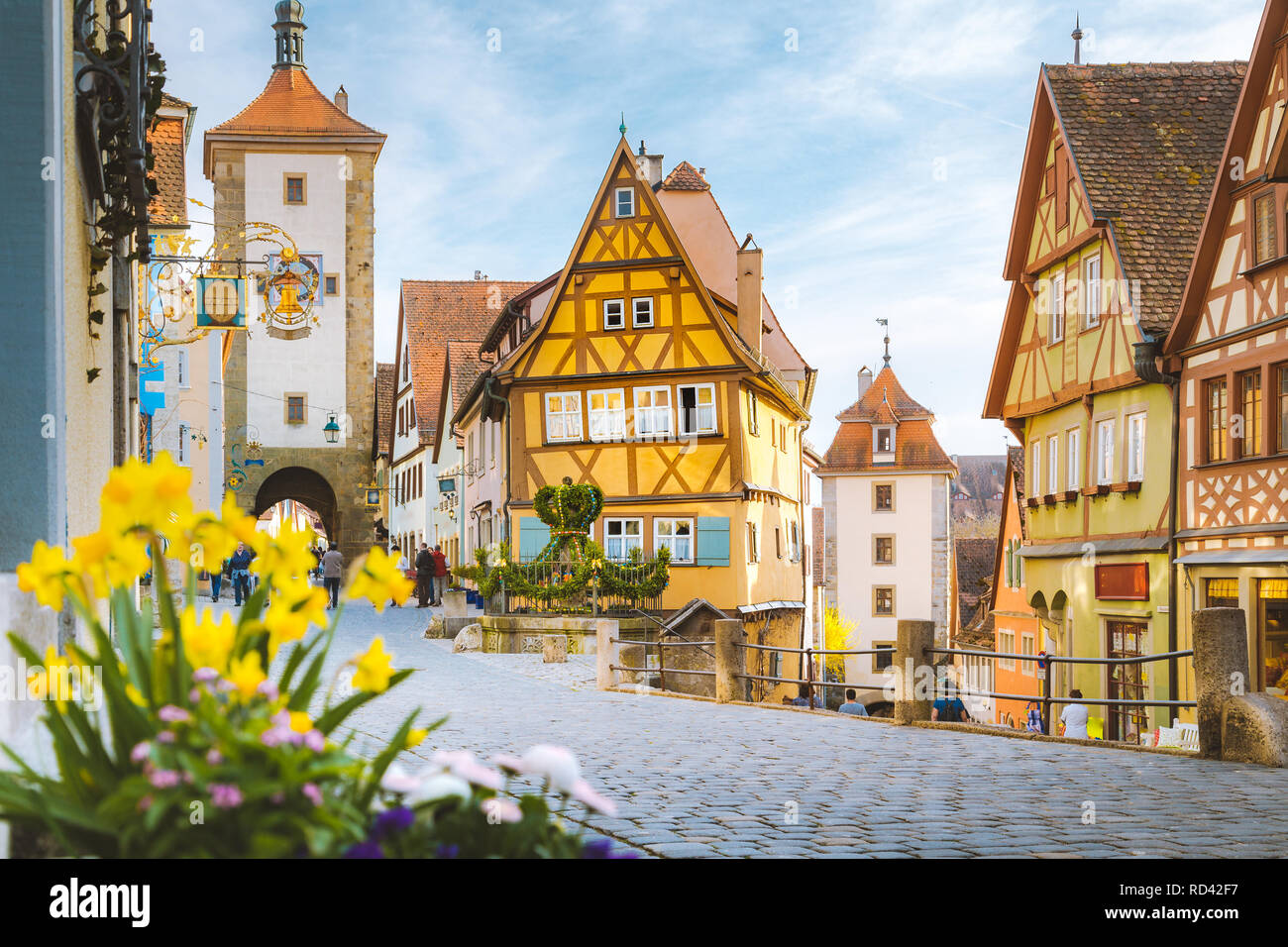 Classic view of the medieval town of Rothenburg ob der Tauber with blooming flowers on a beautiful sunny day with blue sky and clouds in springtime, B Stock Photo