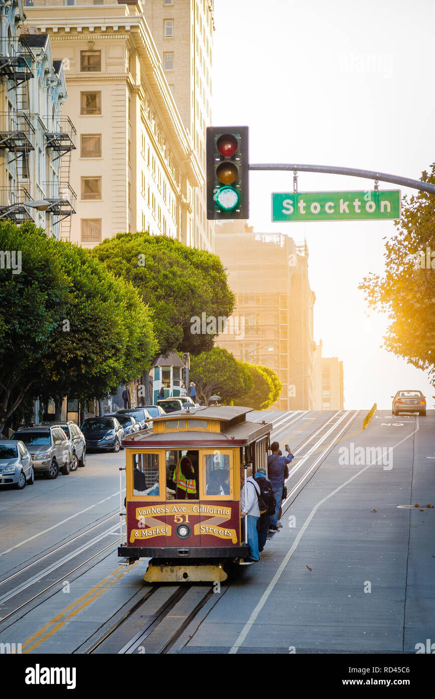 Historic Cable Cars riding on famous California Street in beautiful golden evening light at sunset, San Francisco, California, USA Stock Photo