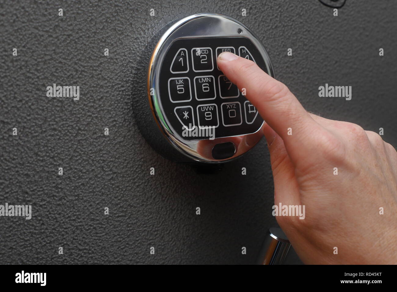 Hand enters combination on digital lock on a safe Stock Photo - Alamy
