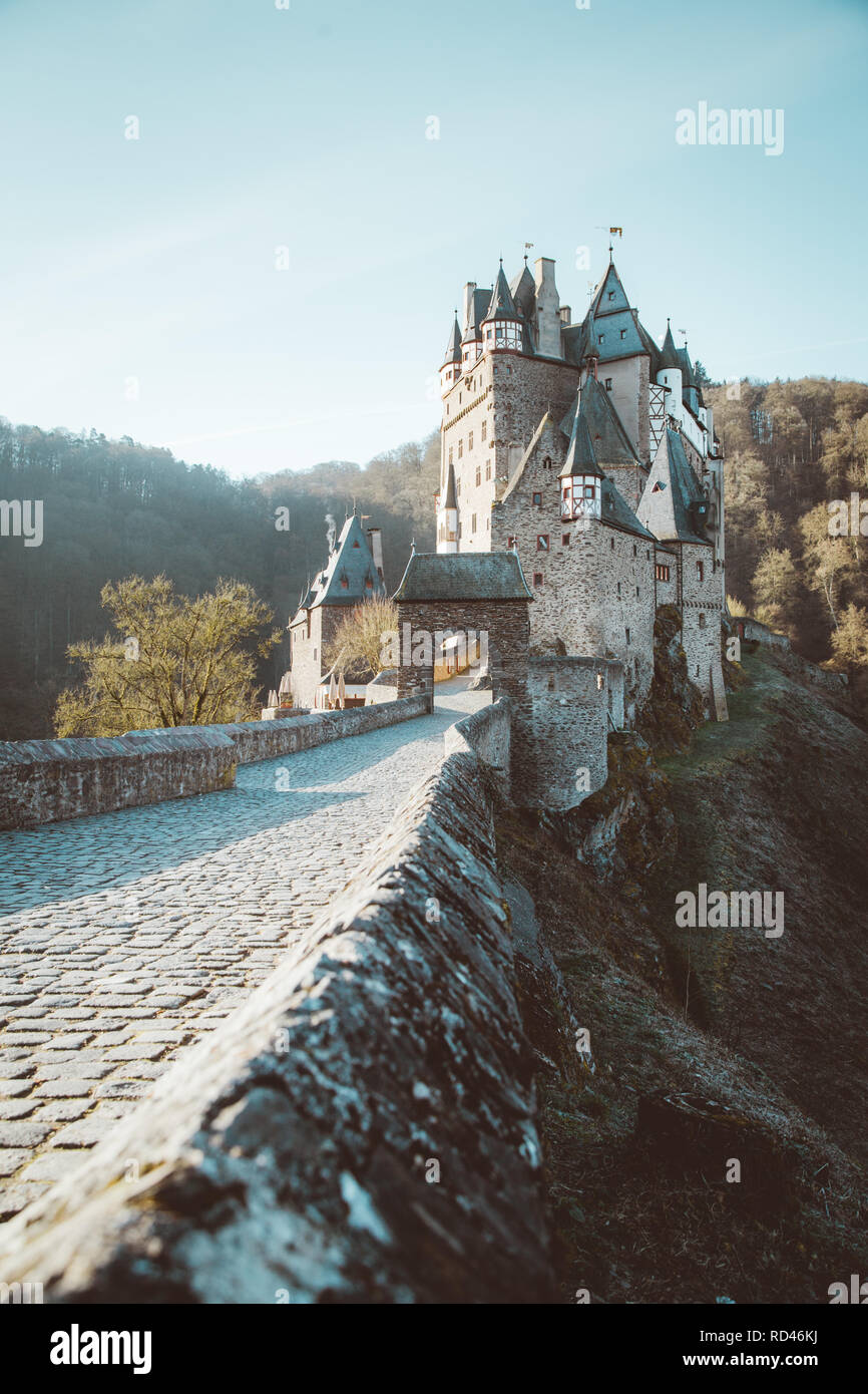 Beautiful view of famous Eltz Castle in scenic golden morning light at sunrise with blue sky on a sunny day in fall with retro vintage VSCO style filt Stock Photo
